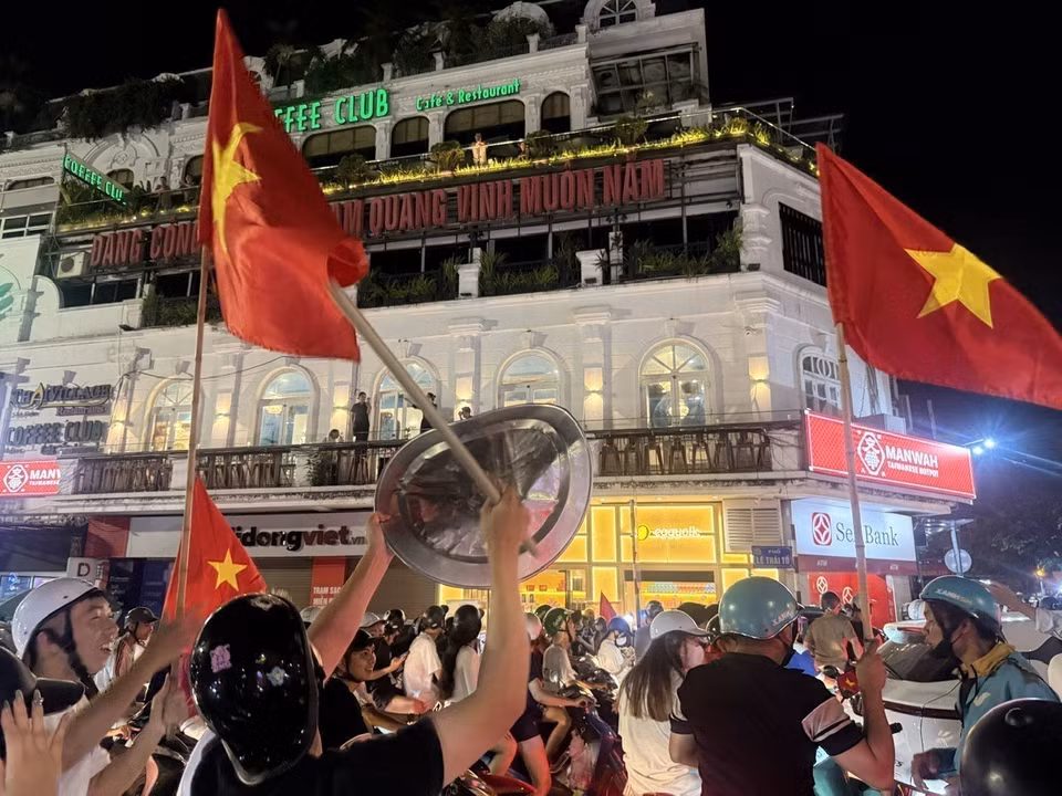 越南首都市民手举祖国国旗，在河内各条街道上游行，热烈欢庆胜利。图自 越通社