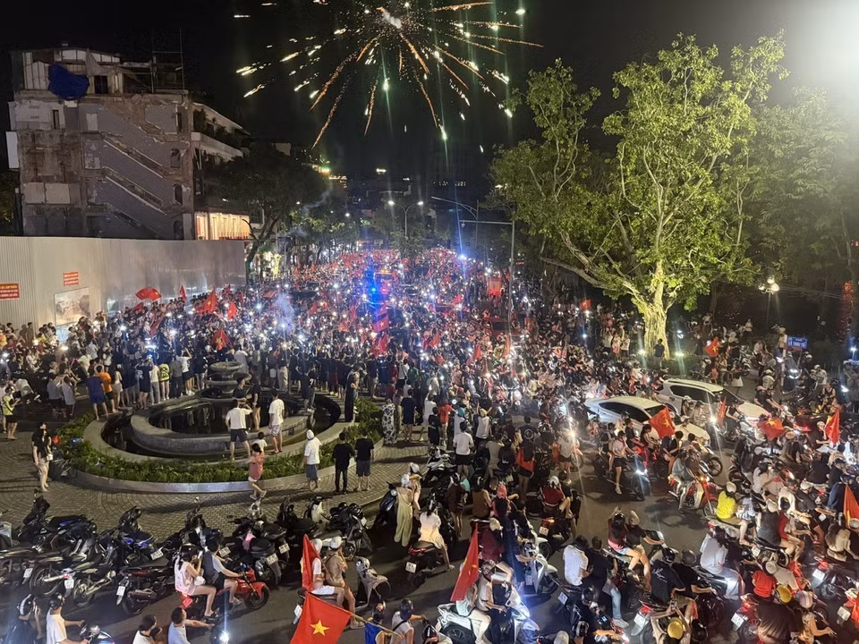 首都市民手举祖国国旗，齐聚东经义塾广场一带，兴高采烈地庆祝胜利。图自 越通社