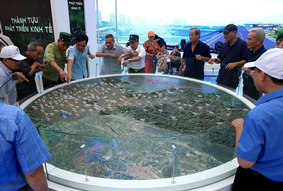 民众在在北宁省展区观看并了解合并后行政区划调整的沙盘模型。图自 越通社