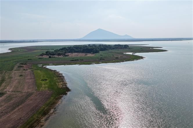 油汀湖——越南最大的人工水利湖，宛若一颗碧玉，静卧于西宁的群山林海之间，展现出宁静而诗意的自然之美。图自 越通社