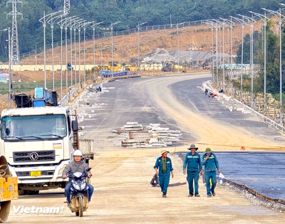 道路路面正在加紧铺设沥青，全长6车道，宽30米。图中，工人们正愉快地准备下班。图自 越通社《Vietnam+》