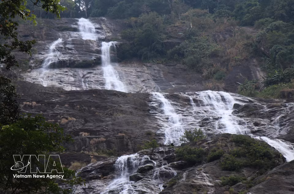 绸瀑布高约300米，层层叠落，水流沿岩壁飞泻而下，宛如一条长长的丝绸铺展于群山峭壁之间。图自 越通社