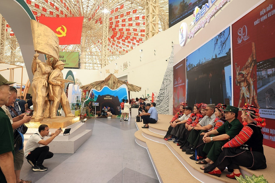 民众在奠边省展区,同哈尼族同胞合影留念。图自 越通社