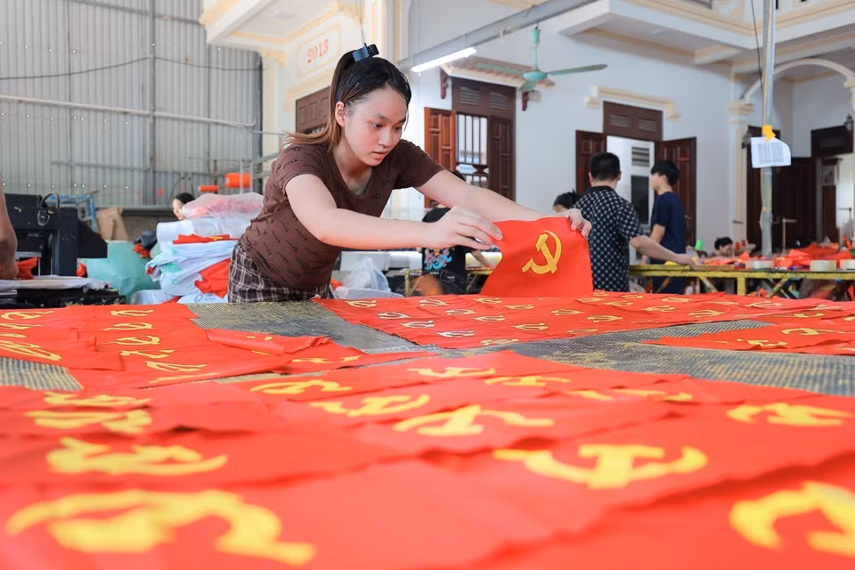 村民在制作旗帜的每一道工序中都一丝不苟、精益求精。图自 越通社