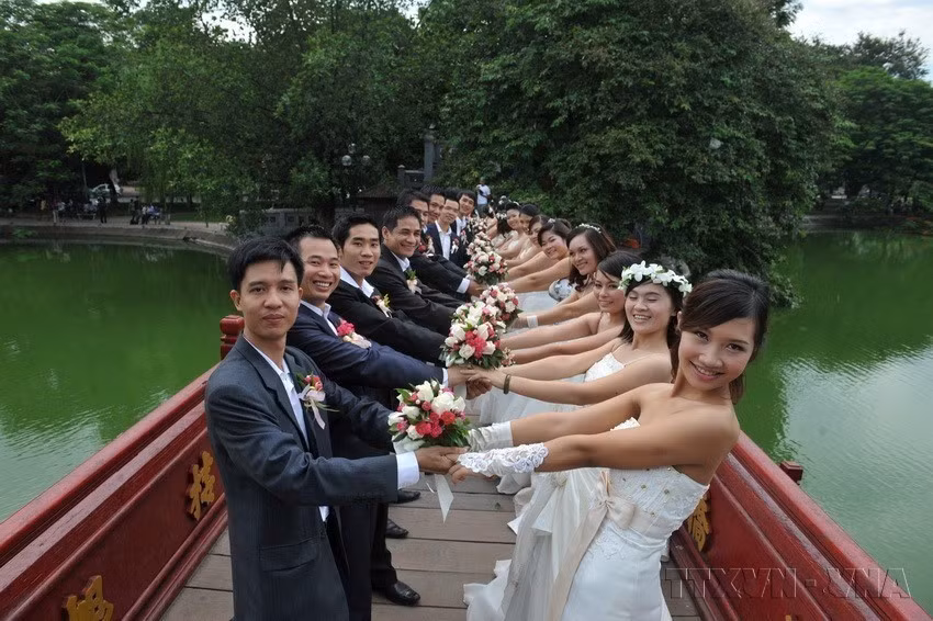 来自越南北、中、南三地的50对新人在河内还剑湖畔举行集体婚纱摄影活动，共同定格幸福瞬间。图自 越通社