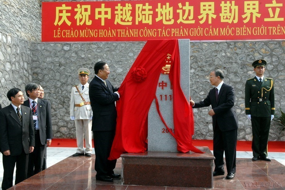 越南政府副总理、外交部长范家谦与中国国务委员戴秉国在越中陆地边界勘界立碑圆满结束仪式上,为伫立中越两国边境的第1117号界碑揭幕(2009年2月23日)。图自 越通社