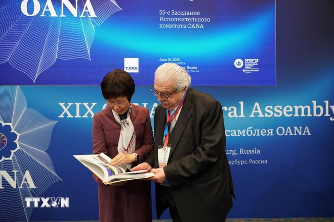 越通社社长武越庄向俄罗斯塔斯社第一副社长米哈伊尔•古斯曼介绍画册《越南革命新闻百年》。图自 越通社