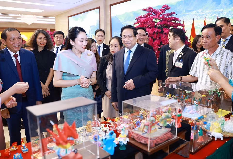 越南政府总理范明政与泰国总理佩通坦·西那瓦一同参观越南传统手工艺品—捏塑产品。图自 月通社