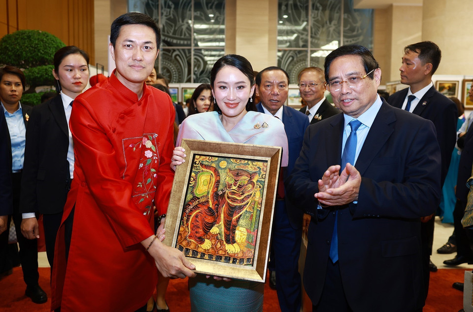 越南政府总理范明政向泰国总理佩通坦·西那瓦赠送一幅传统漆画作品。图自 越通社