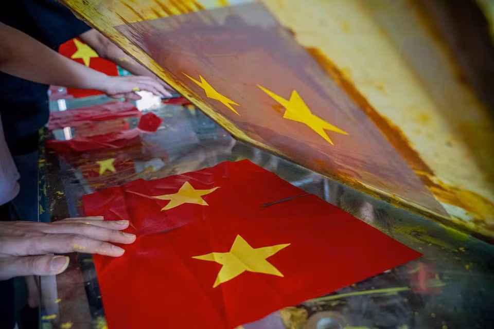 村民在制作旗帜的每一道工序中都一丝不苟、精益求精。图自 越通社