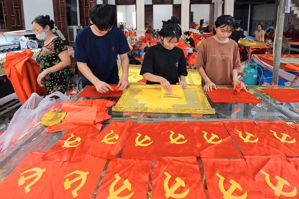 村民在制作旗帜的每一道工序中都一丝不苟、精益求精。图自 越通社
