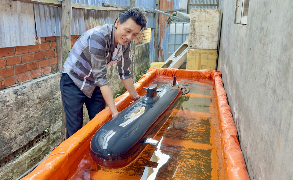 阮方弟先生在交付给客户前测试潜艇模型的运行状况。图自 越通社