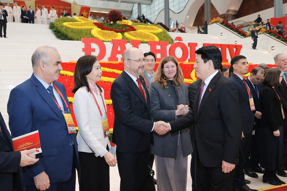 越南国家主席梁强在越南共产党第十四次全国代表大会闭幕会议期间同出席会议的国际代表互动交流。图自 越通社