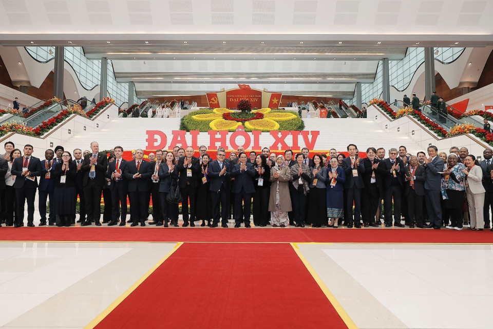 越南政府总理范明政在越南共产党第十四次全国代表大会闭幕会议期间同出席会议的国际代表互动交流。图自 越通社