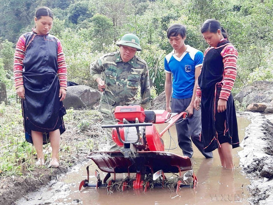 莱州省边防部队的干部战士们引导当地群众使用拖拉机进行耕作，旨在提高农业生产效率。图自 越通社