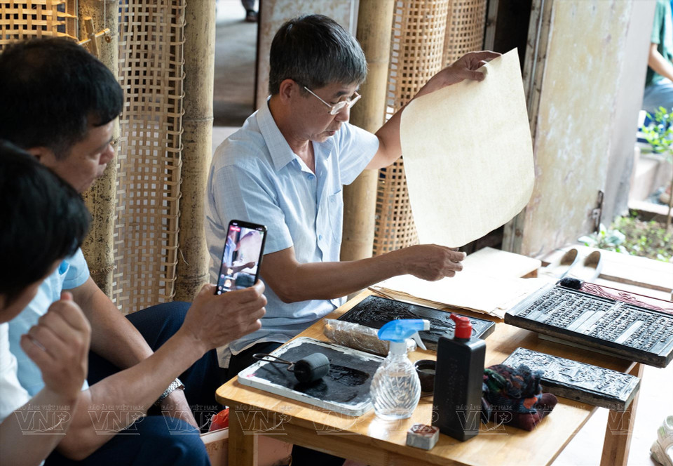 参观者亲眼目睹传统手工艺品的制作过程。图自越通社