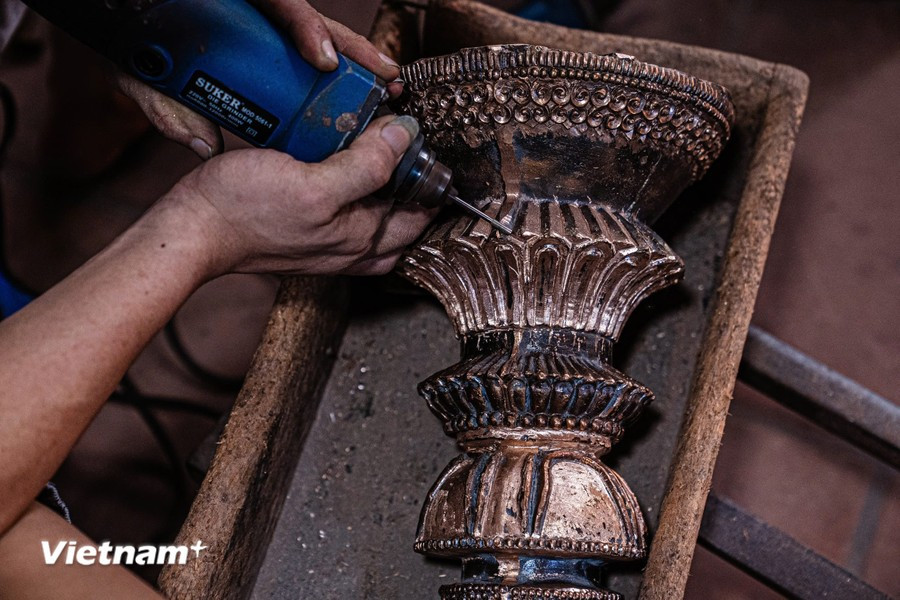 在工匠们的心灵巧手下，这些铜块在被打磨前经历了“脱胎换骨”的过程。图自 越通社《越南画报》