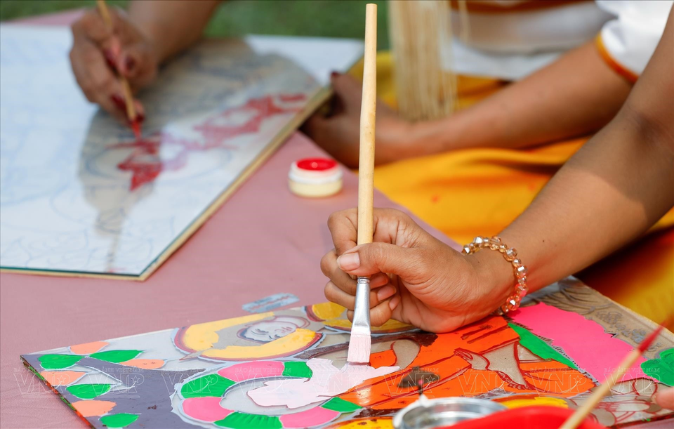 与在其他材料绘制不同，在玻璃上绘制首先必须画出图案。图自 越通社《越南画报》