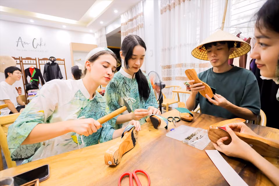 外国游客体验制作木鞋的乐趣。图自越通社/越南画报