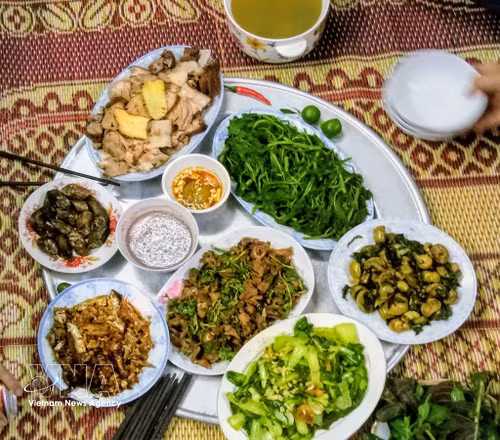 围坐在铺在地板上的草席上用餐——越南朴实而充满热情的食俗，也是陈先生深刻体会当地人细致与真诚的地方。图自越通社
