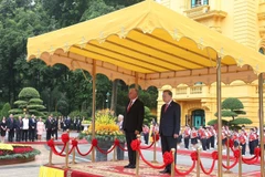 两位领导登上检阅台，军乐队奏起两国国歌。图自越通社