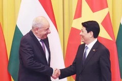 越南国家主席梁强与匈牙利总统舒尤克·道马什亲切握手。图自越通社