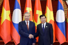 越共中央总书记苏林与老挝人民革命党中央总书记、国家主席通伦·西苏里亲切握手。图自越通社