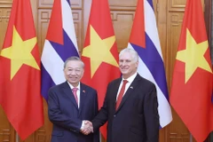 苏林总书记与古共中央第一书记、国家主席迪亚斯-卡内尔亲切握手。图自越通社