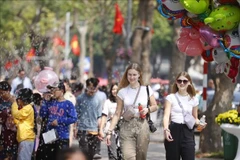 国际游客在还剑湖步行街游览。图自越通社