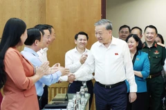 苏林与各位代表亲切交流。图自越通社