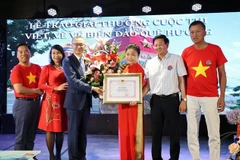 武光明大使向获奖者颁发奖状。图自越通社