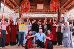 考察团与当地艺人合影留念。图自富寿报