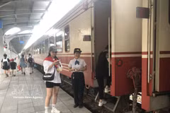 旅客在海防站上车前接受检票。图自越通社