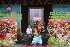 安江省越南祖国阵线委员会副主席裴文赠（左）送花祝贺和好佛教创立86周年。图自越通社