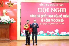 越共中央政治局委员、中央书记处书记、中央组织部部长黎明兴向越共中央委员、民族与宗教部常务副部长胡文年同志颁发任命书。图自越通社