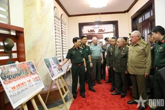 潘文江向各国代表介绍有关庆祝越南国庆80周年的图片展。图自人民军报