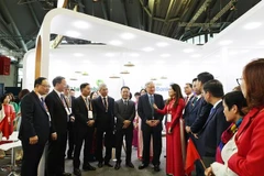 阮和平副总理参观越南国家银行展位。图自越通社