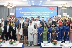 出席亮相仪式的代表们和学生们合影。图自越通社
