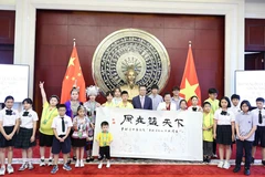范青平大使与两国少年儿童合影。图自越通社