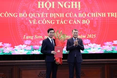 政治局委员、中央书记处书记、中央组织部部长黎明兴向黄国庆同志颁发任命决定。图自越通社
