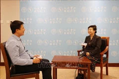 中国人民大学重阳金融研究院研究员刘英(右)接受越通社记者的采访。图自越通社