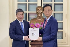 越南友好组织联合会主席潘英山（左）与广西壮族自治区外事办公室主任、对外友好协会会长魏然合影。图自越通社