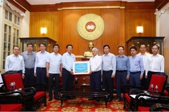建设部领导向越南祖国阵线中央委员会主席杜文战移交捐款。图自越南妇女报