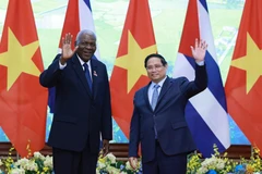 越南政府总理范明政与古巴全国人民政权代表大会主席埃斯特万·拉索。图自越通社