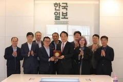 越南新闻工作者代表团与《韩国日报》代表合影。图自越通社