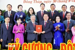 越共中央政治局委员、中央书记处书记、中央宣传与民运部部长阮仲义（左四，前排）与各位代表合影。图自越通社