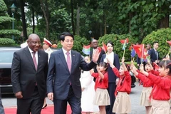 国家主席梁强与南非总统马塔梅拉·西里尔·拉马福萨向首都河内的少年儿童挥手致意。图自越通社