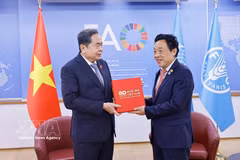 越南国会主席陈青敏向联合国粮农组织总干事屈冬玉赠送“越南国会80周年”书籍。图自越通社