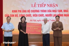 越南国家银行行长阮氏红向越南祖国阵线中央委员会递交银行职工捐赠的款项。图自越通社 