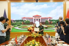 越共中央委员、中央军委常委、国防部副部长黄春战上将向美国国际开发署（USAID）驻越南首席代表阿勒·格拉布斯授予奖状。图自越通社